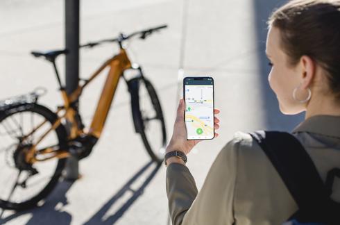 Abbildung Fahrrad und Frau mit Smartphone